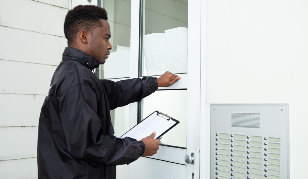 Man in black jacket holding a clipboard and knocking on the front door of a property